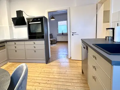 helle und moderne Küche mit Backofen, Herd und Spülmaschine