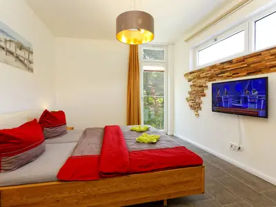 Schlafzimmer mit Doppelbett und Flatscreen TV