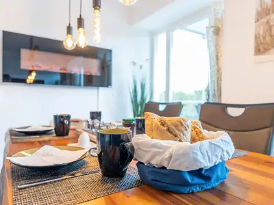 Wohn/Essbereich: Sofa, Sitzbereich, Essbereich, TV, Elektrokamin, Zugang zum Balkon