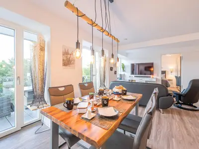 Wohn/Essbereich: Sofa, Sitzbereich, Essbereich, TV, Elektrokamin, Zugang zum Balkon