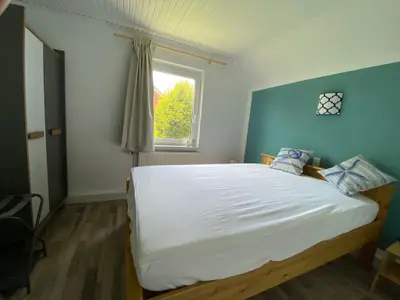 Schlafzimmer mit Doppelbett und Gartenblick