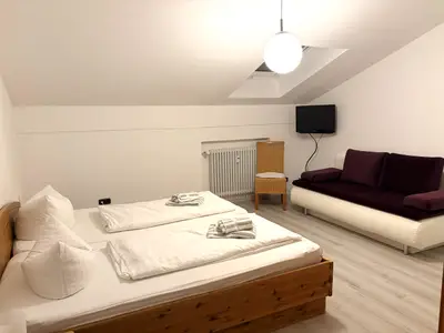 Schlafzimmer mit Schlafcouch im oberen Schlafbereich und zweiten Badezimmer