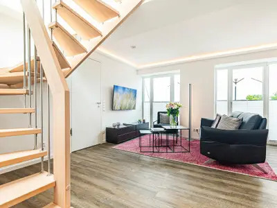 Wohnbereich/Essbereich: Sofa, TV, Beschattungs-Plissess, Treppenaufgang zur Dachterrasse, Zugang zum Balkon