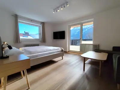 Schlafzimmer mit Doppelbett und gemütlicher Couch