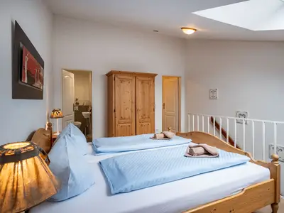 Schlafzimmer mit Doppelbett und Zugang zum WC