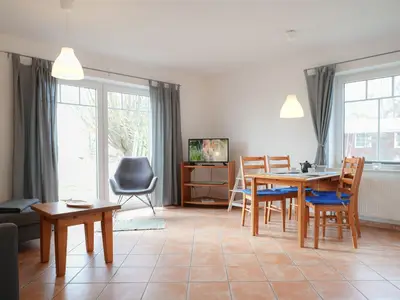 Gemütliches Wohnzimmer mit einladendem Essbereich und modernen Annehmlichkeiten.