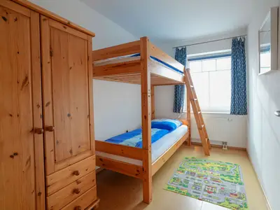 Schlafzimmer mit Etagenbett und Kleiderschrank.