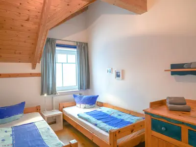 Gemütliches Schlafzimmer mit viel Tageslicht und zwei Einzelbetten.