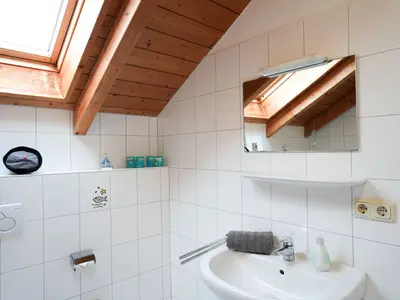 Modernes Badezimmer mit viel natürlich Licht durch Dachfenster.