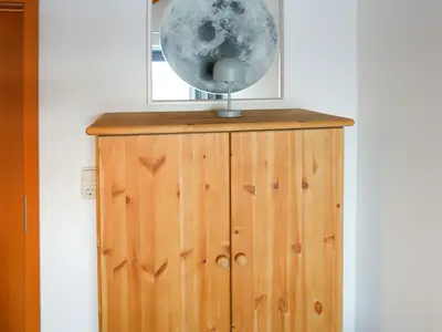 Entdecken Sie den Komfort dieses stilvollen Schlafzimmers mit Holzschrank und modernem Flair.