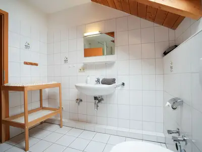 Modernes Badezimmer mit elegantem Waschbecken und großem Spiegel.