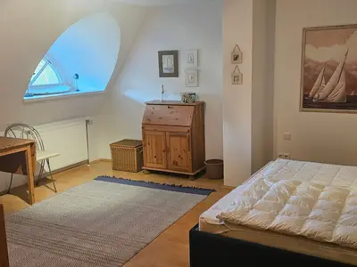 Schlafzimmer mit Doppelbett und Sitzbereich