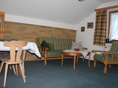 Wohn-Schlafzimmer mit Sitz und Essecke