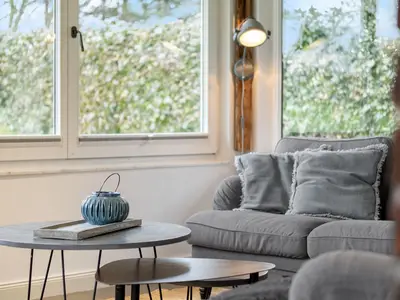 Der Wintergarten als Wohnzimmer mit 2 Sofas und TV