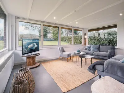 Der Wintergarten als Wohnzimmer mit 2 Sofas und TV