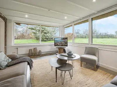 Der Wintergarten als Wohnzimmer mit 2 Sofas und TV