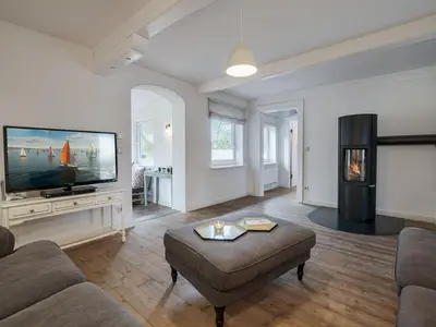 Wohnzimmer mit Kamin, TV und 2 Sofas