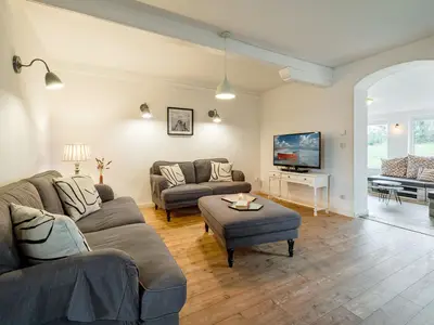 Wohnzimmer mit Kamin, TV und 2 Sofas