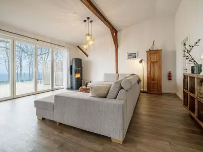 Offenes Wohnzimmer mit Couch, Meerblick, Ofen und Essbereich