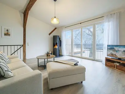 Wohnbereich mit Meerblick, Couch, Ofen und Küche