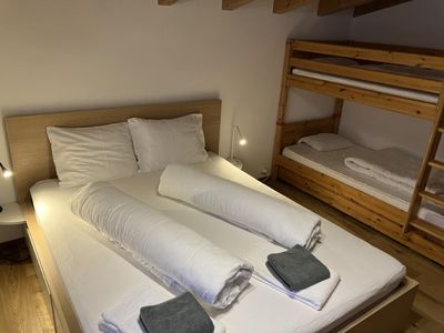 Schlafzimmer mit Doppelbett und Etagenbett. Bergsicht