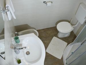 Das Badezimmer mit Dusche, WC, Bidet, Waschbecken mit Spiegel