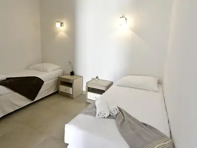 Schlafzimmer 2 mit zwei Einzelbetten und zwei Nachttischen.