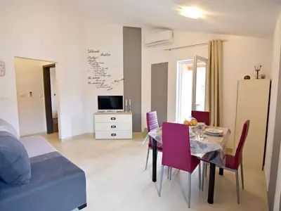 Der Wohnbereich mit Flachbild-Sat-TV, Esstisch mit Stühlen
