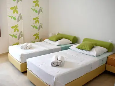 Das Schlafzimmer mit zwei Einzelbetten, Nachttischen und Nachtlampen