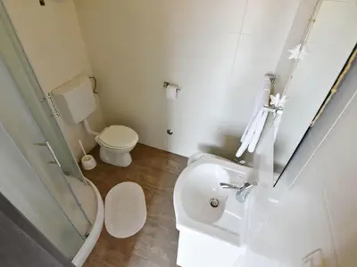 Das Badezimmer mit Dusche, WC, Bidet, Waschbecken mit Spiegel