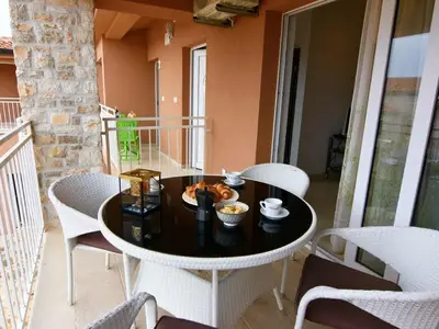 Die überdachte Terrasse mit Tisch und Stühlen mit Blick auf den Pool