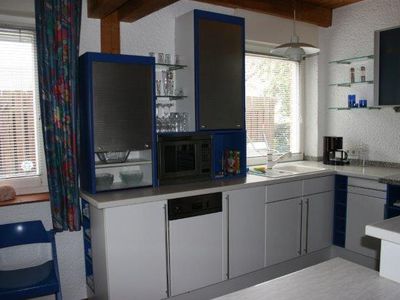 Küche mit Herd, Cerankochfeld, Mikrowelle, Kühlschrank und großer Arbeitsfläche