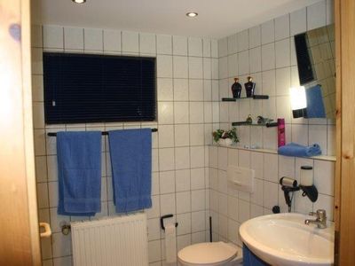 Badezimmer mit Spiegel, Waschbecken, WC und Dusche