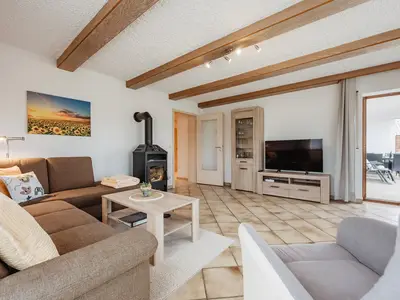 Ferienwohnung Wohnzimmer mit Kaminofen, Smart TV und Ausgang zur Terrasse