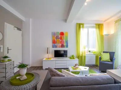 Gemütlicher Wohnbereich mit TV & Sessel – stilvoll entspannen in der Ferienwohnung Beach Lounge Timmendorfer Strand.