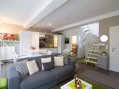 Wohnbereich mit Schlafcouch & offener Küche – stilvolle Ferienwohnung Beach Lounge am Timmendorfer Strand.