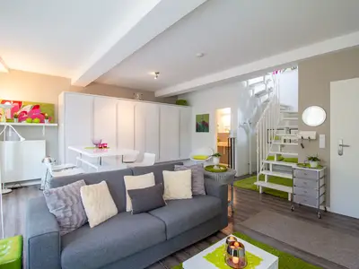 Wohnbereich mit Schlafcouch & offener Küche – stilvolle Ferienwohnung Beach Lounge am Timmendorfer Strand.