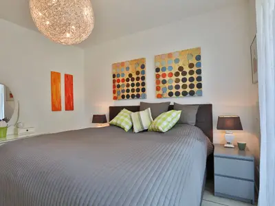 Schlafzimmer mit Boxspringbett in der Ocean Breeze No 6, Niendorf am Timmendorfer Strand – modern, hell und einladend.
