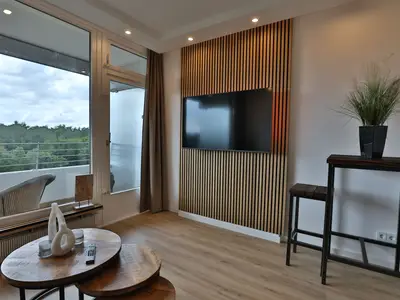 Strandkoje 6: Moderner Wohnbereich mit TV, Bartisch und großem Fenster mit Weitblick in Timmendorfer Strand.