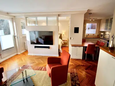 Heller Wohn- & Essbereich der Seepferdchen Suite mit Zugang zum Balkon & moderner Technik. Ihr perfektes Urlaubsdomizil.