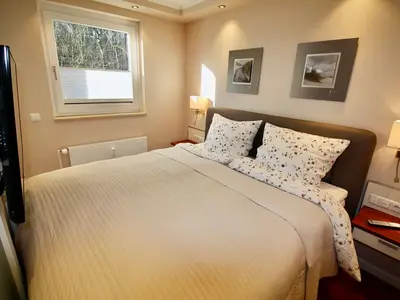 Seepferdchen Suite: Gemütliches Schlafzimmer mit Boxspringbett und TV.