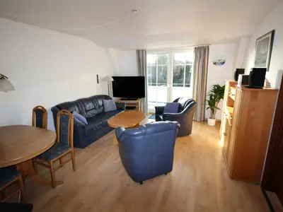 Parkside No. 8 – Helles Wohnzimmer mit Sitzgruppe, Essbereich und Zugang zum Balkon.