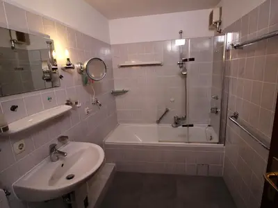 Modernes Bad im Parkside No. 8 – mit Badewanne, Glasduschwand und viel Komfort.