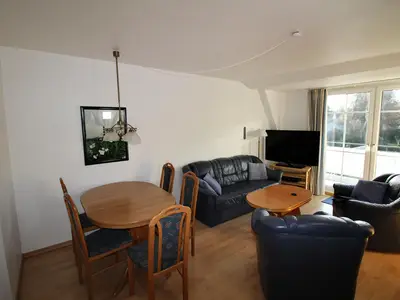 Parkside No. 8 – Helles Wohnzimmer mit Essbereich, Couch und großem Fenster.