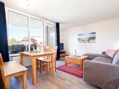 Wohnzimmer mit Couch, Fernseher und Sitzecke
