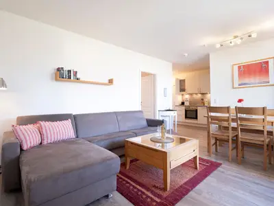 Wohnzimmer mit Couch, Fernseher und Sitzecke