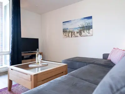 Wohnzimmer mit Couch, Fernseher und Sitzecke