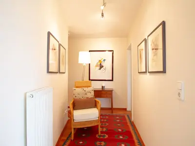 Küsten Lodge: Heller Flur mit Sessel und Kunst in Niendorf in der Nähe zum Timmendorfer Strand.