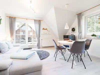 Wohnzimmer mit Couch, Fernseher und Sitzecke