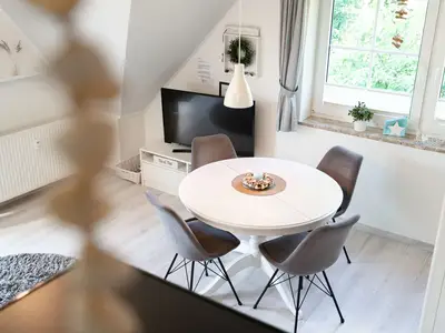 Wohnzimmer mit Couch, Fernseher und Sitzecke